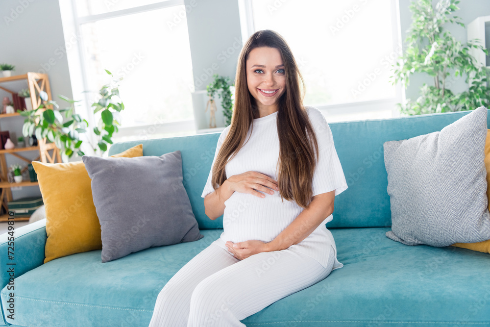 Sticker Photo of lovely adorable cute girl wearing white pajama hands touching tummy pregnancy moment period living room indoors