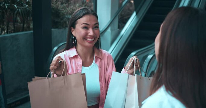 Two friends shopping mall showcasing bags full of shopping radiating women's emotions. Women's emotions joy evident smiles laughter Women's emotions reflect happiness elegance shopping spree.