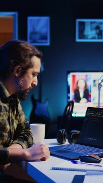 Vertical video Skilled computer scientist writes code on laptop screen while in living room office using programming languages. Self employed IT specialist working on fixing database errors from home