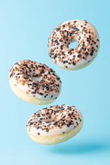 Fresh donuts on blue background. Minimal food concept.