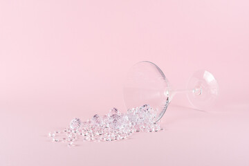 Creative layout made of martini cocktail glass with diamonds on pastel pink background. Minimal...