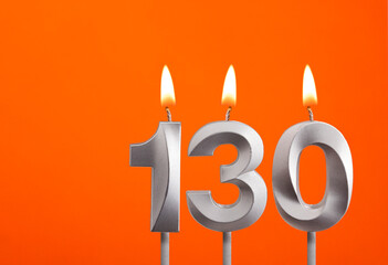 130 candle - Birthday celebration on orange background