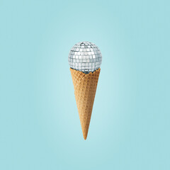 Disco ball in ice cream cone on a blue background. Minimal party concept.