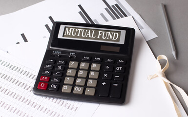 MUTUAL FUND text on calculator with chart on grey background
