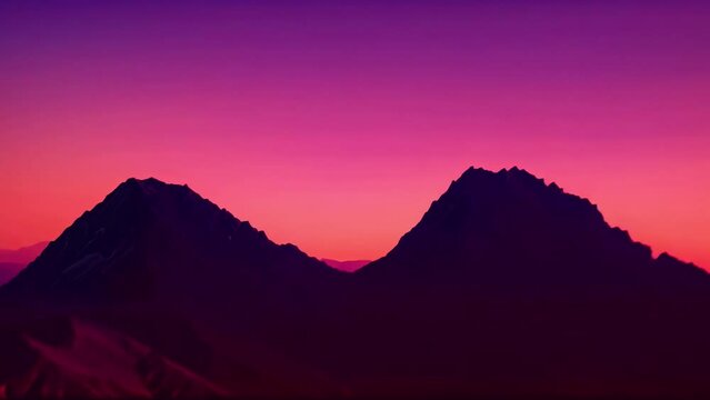Experience the breathtaking beauty of majestic mountains set against a vivid palette of purple and pink hues in the sky.