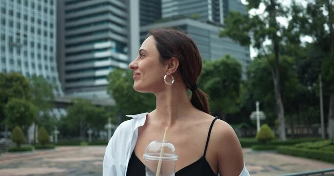 Against Bangkok's modern skyscrapers woman looks around close-up Bangkok fusion of old and new in architecture. Bangkok forefront of technological innovation Modern capital of Thailand.