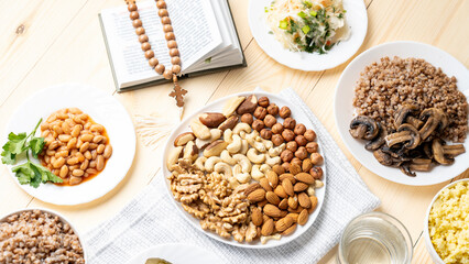 Bible rosary and various nuts on white plate on wooden background during great Christian lent, Lenten food during the Great Orthodox Lent