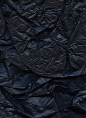 Dark crumpled paper texture. Minimalistic background. Charcoal paper backdrop. Noir cardstock...
