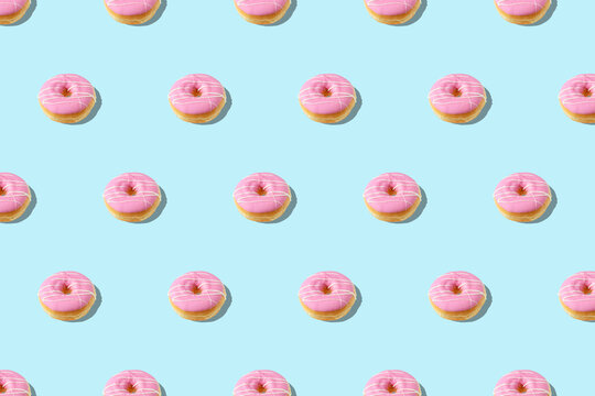 Trendy summer pattern with pink donut on bright blue background. Minimal summer concept.