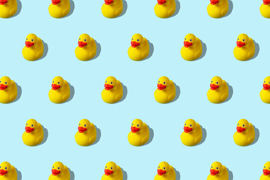 Trendy summer pattern with yellow rubber duck on bright blue background. Minimal summer concept.