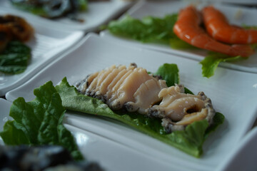 Fresh raw abalone sashimi is served.
