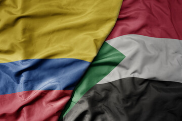 big waving national colorful flag of sudan and national flag of colombia .