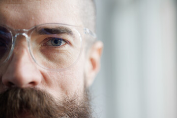 Close-up portrait of a brutal young man in glasses.