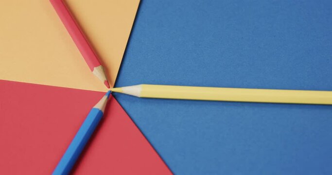 Close up of crayons on colourful background, in slow motion