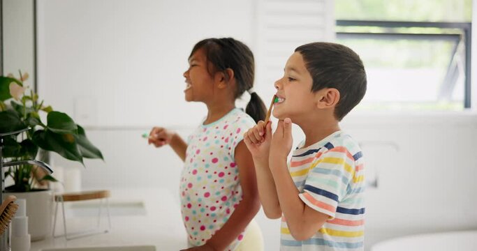Siblings, learning or children in bathroom brushing teeth together for development in morning at family home. Boy, girl or kids cleaning mouth with toothbrush for dental or oral health for wellness