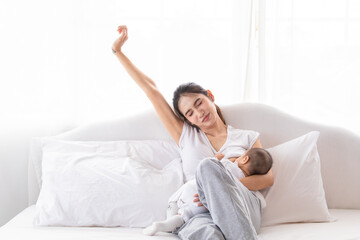 Selective focus young Asian beautiful mother hold newborn baby 0-1 month in her arms with love, gently, infant happy sleeping mom looking infant , newborn baby feeling secure while sleeping in mom arm