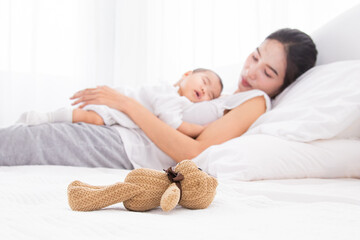 Asian beautiful mom motherhood lie down nursing, kissing newborn baby infant toddler, gently hold...