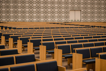 Auditorium perspective with benches and wall with texture in blur in the background