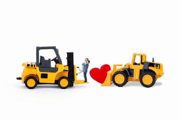 Miniature couple on forklift truck and red heart on front loader truck isolate on white background, love and romance concept, valentine background idea - Powered by Adobe