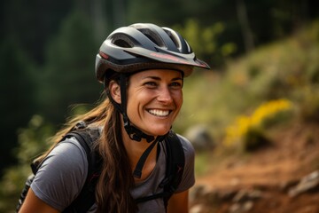 Portrait of a smiling woman with a helmet on a mountain trail - obrazy, fototapety, plakaty