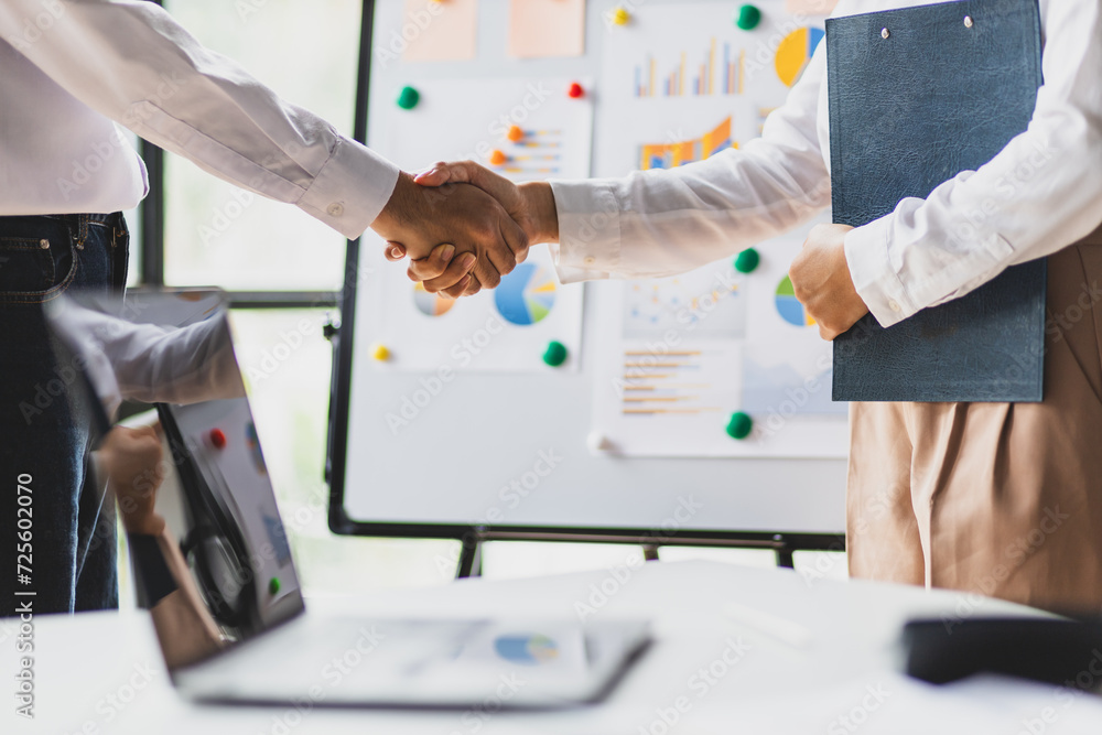 Wall mural meeting of business partners shaking hands in the office.