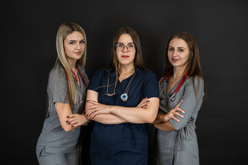 Group of three young female doctor or nurse wear uniform stethoscope isolated on black