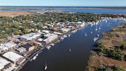 Fototapeta na wymiar Cars and boats in small town USA historic Georgetown, SC with front street business and homes by Winyah Bay waterway in South Carolina Low Country