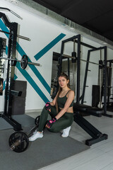 Portrait of an attractive woman instructor stand at gym and look at camera