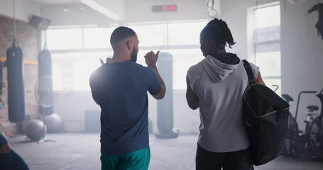 Trainer, athlete and walking in gym for boxing advice or sports from behind for performance, talk or fitness. Male person, wellness and physical activity in club chat for challenge, health or cardio