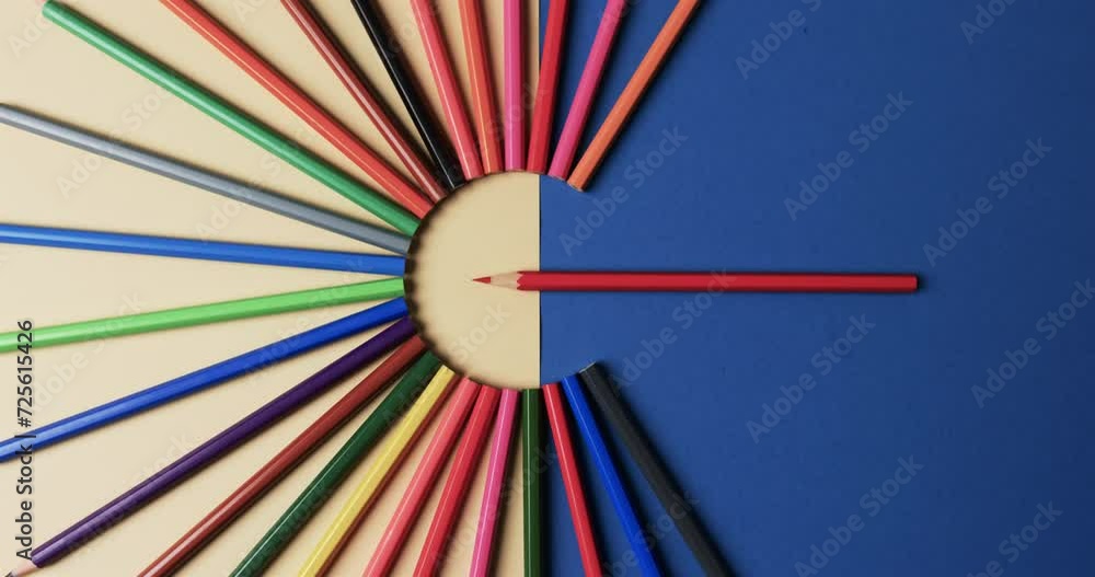 Poster Overhead view of crayons arranged on beige and blue background, in slow motion