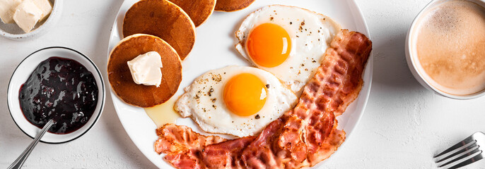 Breakfast with fried eggs, bacon and pancakes