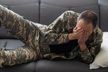 man in military clothes sleeping on the couch