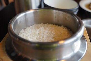Rice in a stainless steel bowl on the wooden table