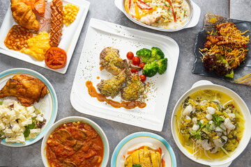 Top view of a set of different dishes like lamb and fish and breakfast on a table in a restaurant