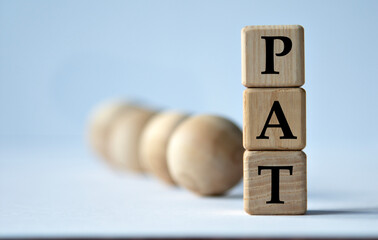 PAT - acronym on a wooden block on a white background with wooden balls