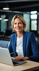 Portrait of smiling businesswoman using laptop at workplace in modern office