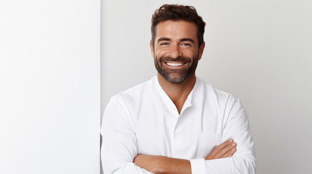 Portrait of handsome businessman standing with crossed arms and looking at camera