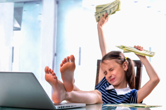 Very happy young girl counting US Dollar bills profit. Business concept. Selective focus on bare feet.