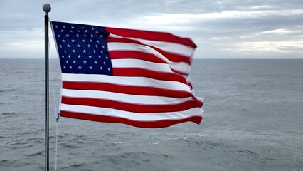 American flag blowing in the wind with ocean in background in coastal South Carolina