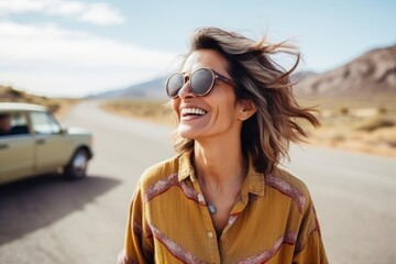 Portrait of a beautiful young woman with sunglasses smiling on the road
