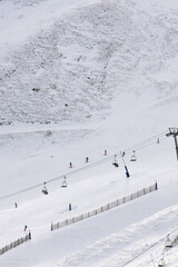 Skiers in the white snow mountains between the city buildings. Snow sports court. Learning grounds for amateur sports and family.