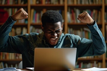 a man with his hands up in front of a laptop