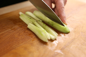 Fresh cucumber is cut into pieces for cooking. Cooking cucumber dishes