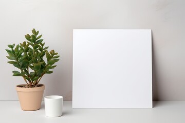 Blank paper copy space template with minimalist interior potted plant decoration on wall background. Stationary mock up.
