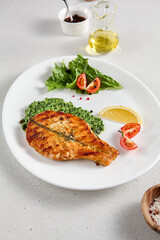 Pan-seared salmon steak with fresh spinach on white plate, perfect for healthy lifestyle and seafood cuisine presentations
