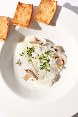 Creamy porcini mushroom soup with cheese espuma and croutons, elegantly presented