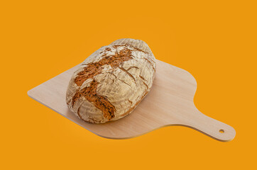 Frisch gebackenes Brot auf einer Holzschaufel vor einem braunen Hintergrund