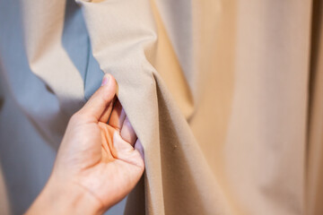 Hand Soft touch natural fabric. The hand is holding the white cloth for choosing a good fabric.