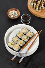 Assorted Sushi Rolls with Shrimp Tartare, Avocado, and Tobiko Caviar on a Modern Dark Surface