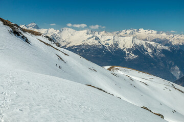 Fototapeta na wymiar Randonnée en hiver dans la neige avec des raquettes , vue sur les Aiguilles d' Arves , massif de la Vanoise , Savoie